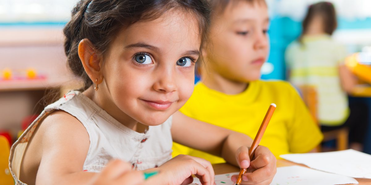 Group of cute little prescool kids drawing with colorful pencils