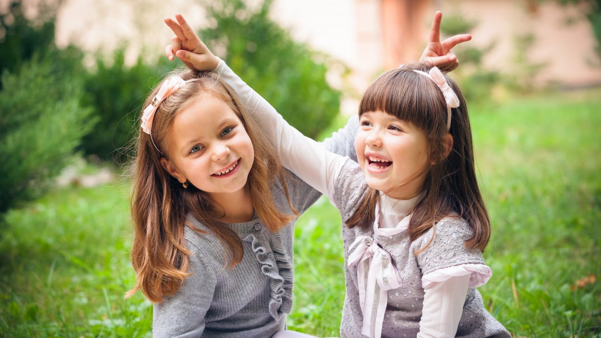 Happy little girlfriends in park